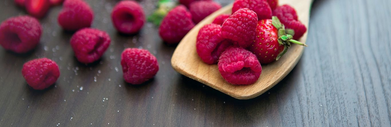 A picture of raspberries over a wooden spoon 