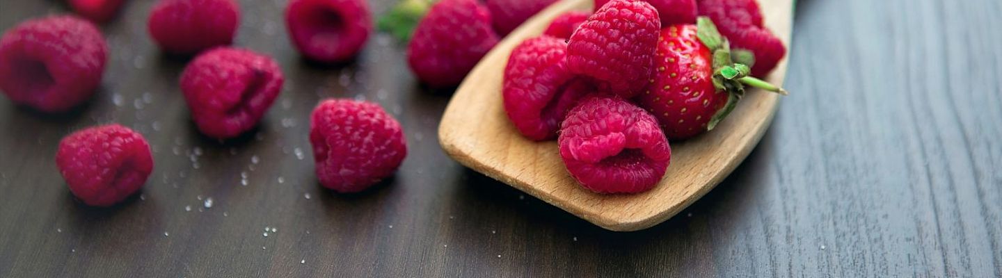 A picture of raspberries over a wooden spoon