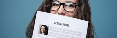 A woman wearing spectacles holds a copy of her Australian-style resume