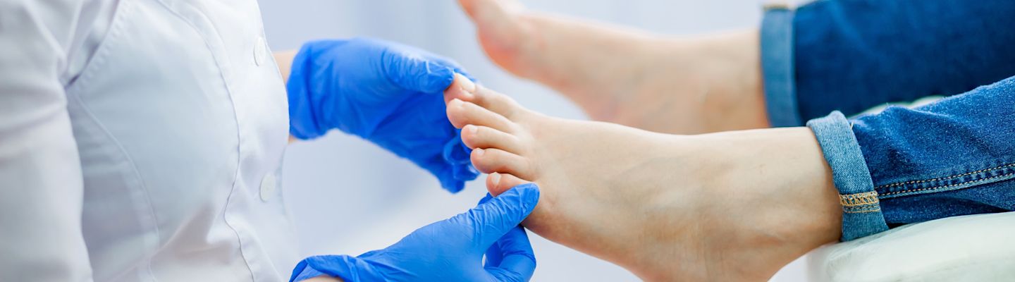 Podiatry doctor examines the foot of a patient