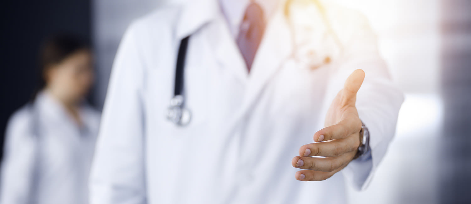 Person wearing a white coat and a stethoscope with an outstretched hand
