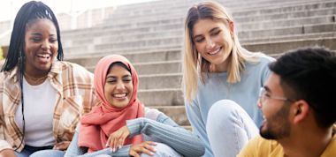 Group of students sitting and chatting in the stairs.