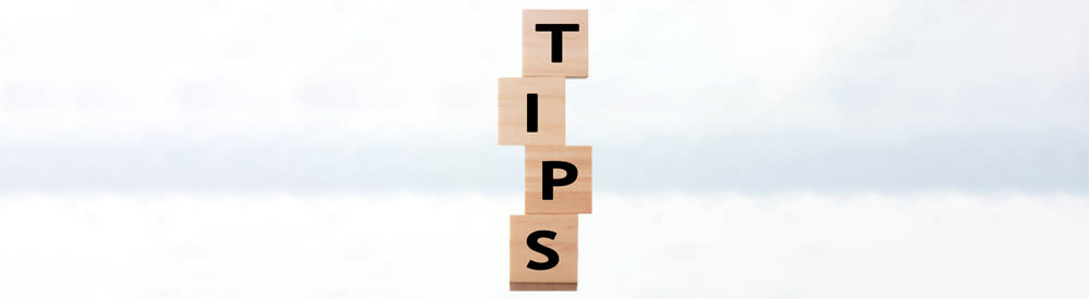 The word TIPS on blocks with a sky background
