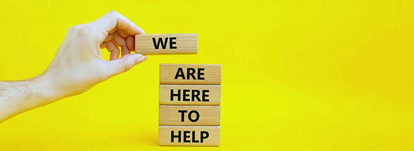 Yellow background, blocks stacked saying WE ARE HERE TO HELP