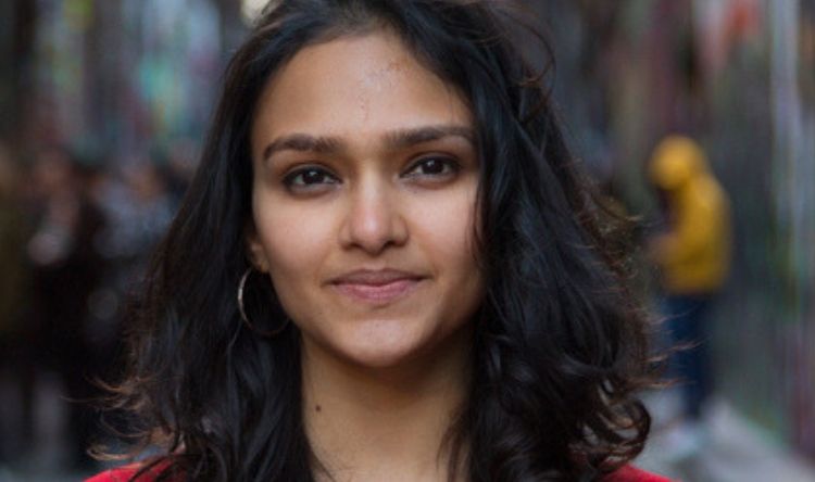 Ushmi poses in the streets of Melbourne in a red top.