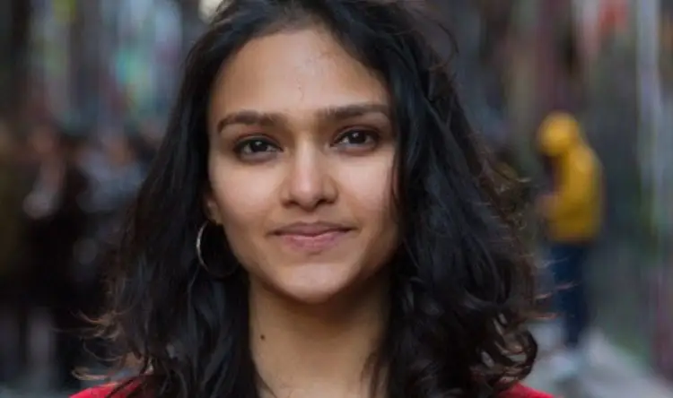 Ushmi poses in the streets of Melbourne in a red top.