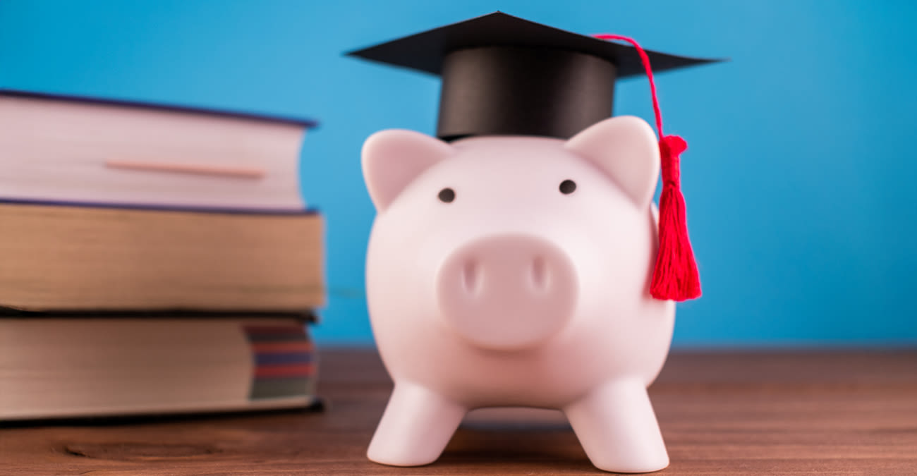 Piggy bank with a graduation hat on a light blue background..