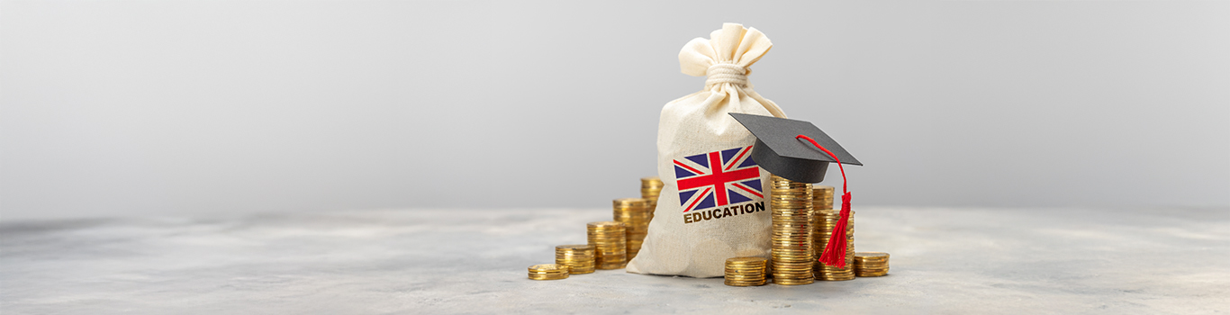 Education in the UK. Scholarships concept. Stack of coins and graduate hat.