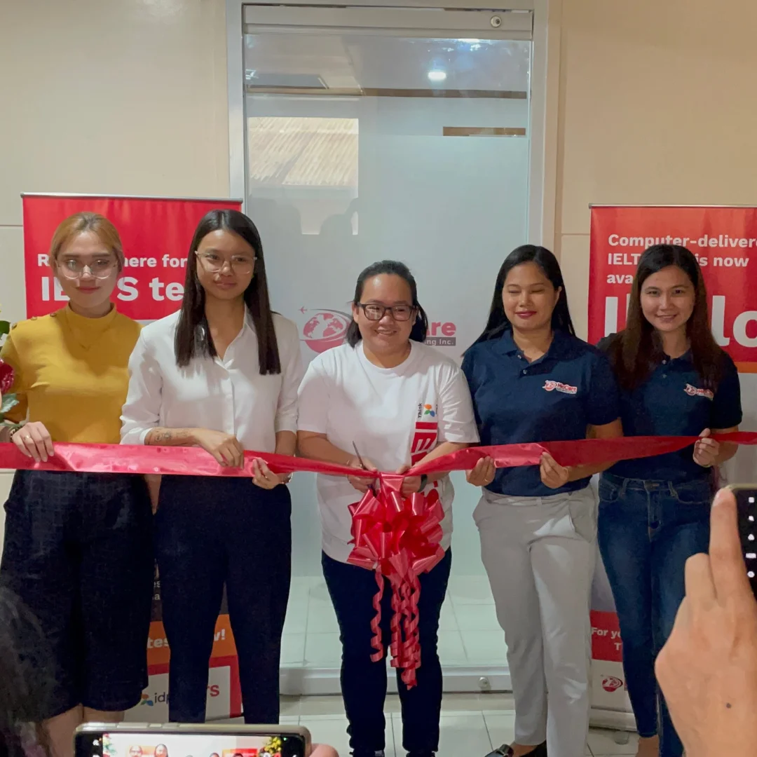5 women holding a red ribbon to celebrate the launch of the new IELTS on Computer Lab in Iloilo, Philippines