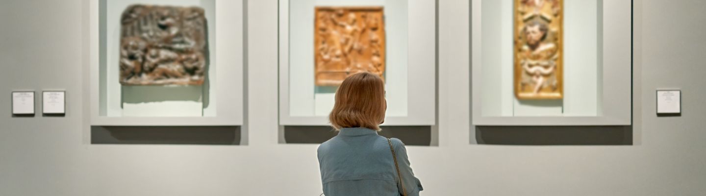 A female student admiring the art works in a museum.