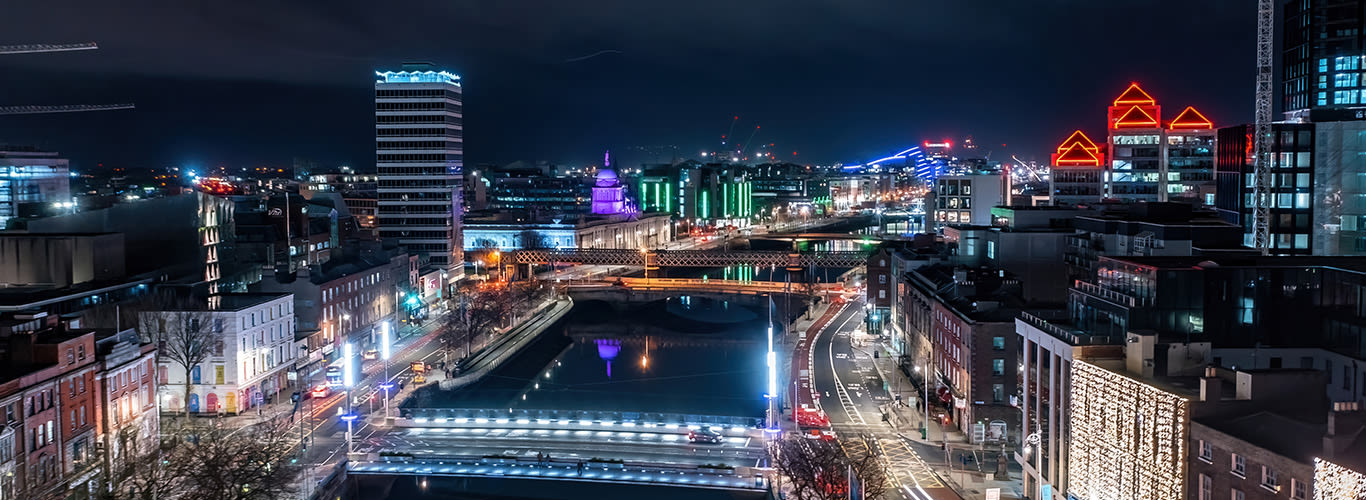 Long exposure aerial shot of Dublin at night, highlighting the city's stunning architecture and festive winter lights. Aerial