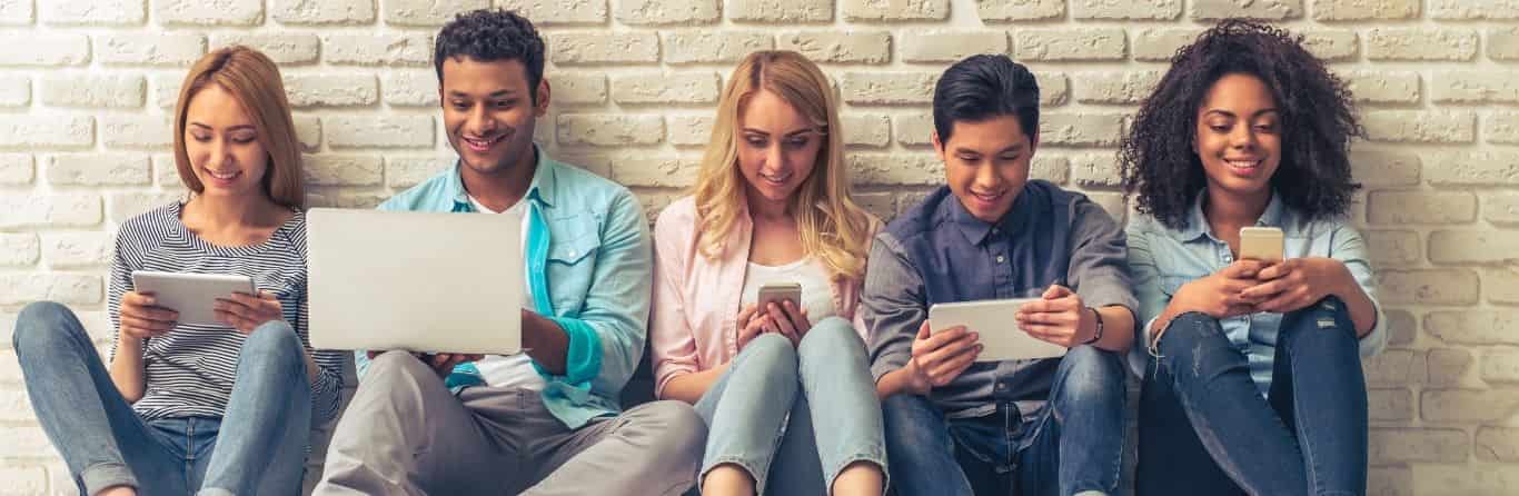 5 young students are using their laptops and smartphones together