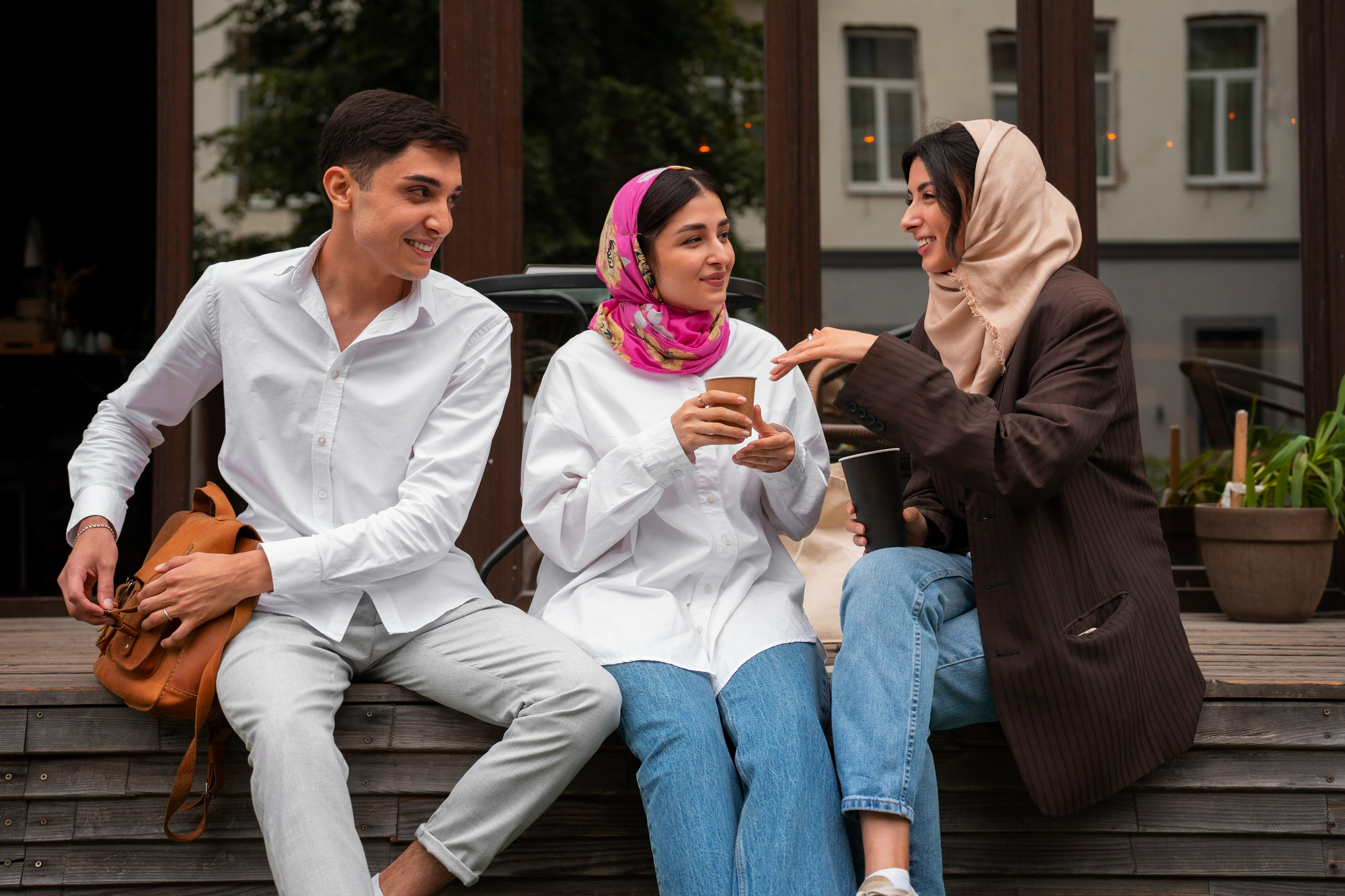 3 students talking and one having a cup of coffee