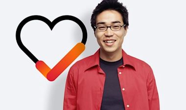 A student wearing red shirt and glasses smiling