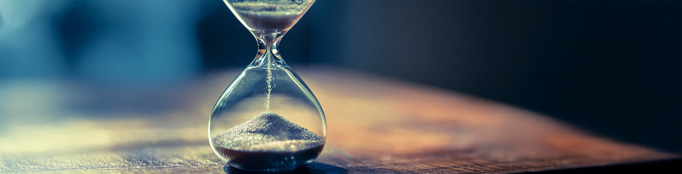 Sand running through the bulbs of an hourglass measuring the passing time