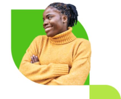 Smiling woman in a yellow sweater with arms crossed, standing in front of a bright green abstract shape