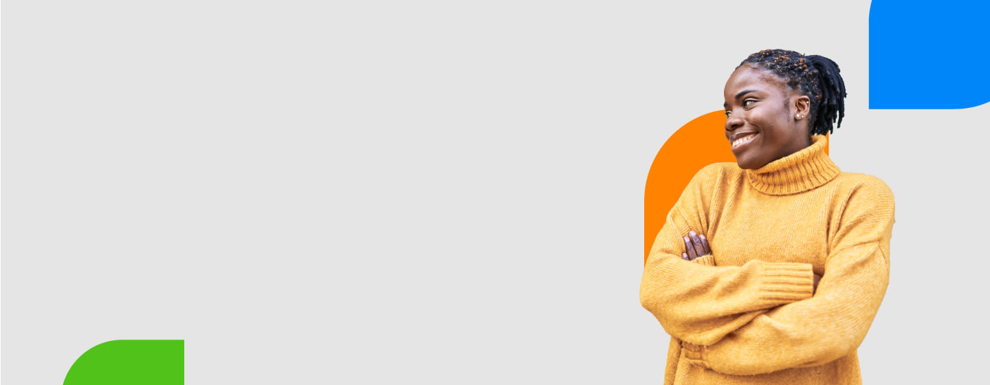 A confident young woman wearing a mustard yellow turtleneck sweater, standing with arms crossed and smiling, with colorful abstract shapes in the background