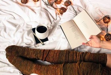 person in bed reading a book