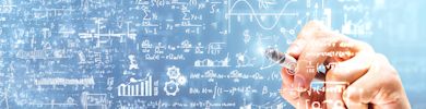 A hand writing mathematical formulas on blurry background.