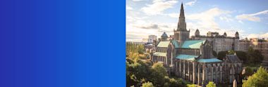 Glasgow Cathedral with tall spire and roof stands majestically among autumn trees under partly cloudy sky in Scotland.
