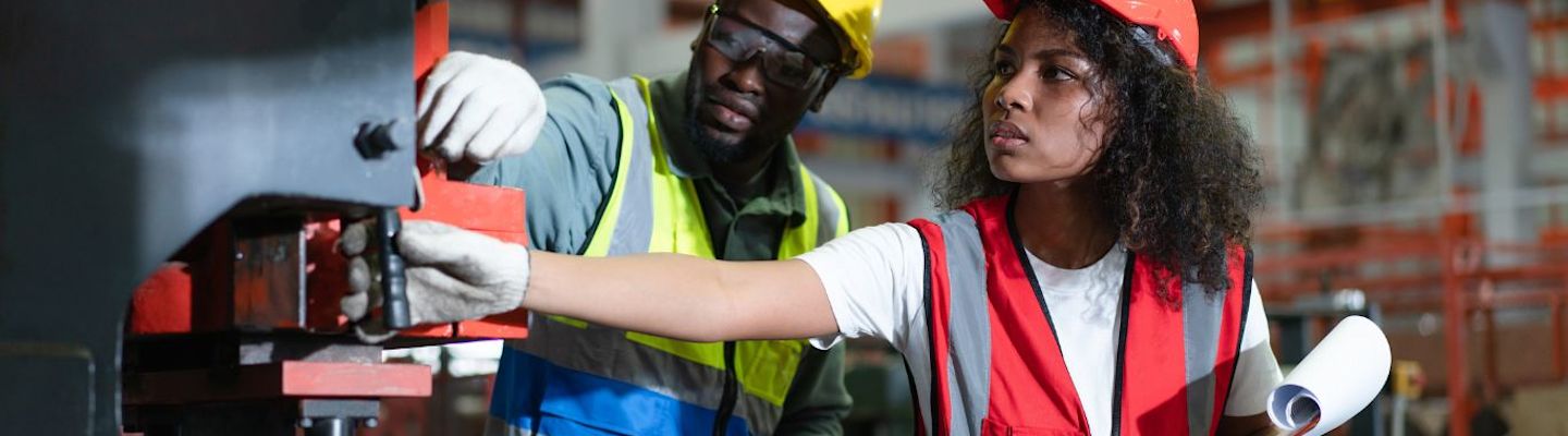 Mechanical Engineering students testing a machine at a factory