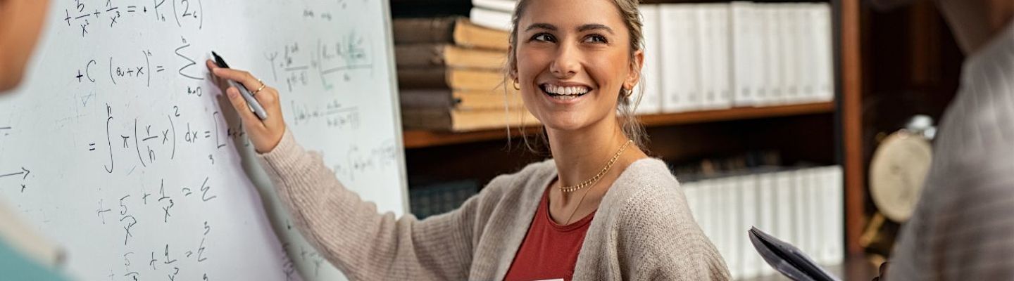 A mathematics female student writing on a white board