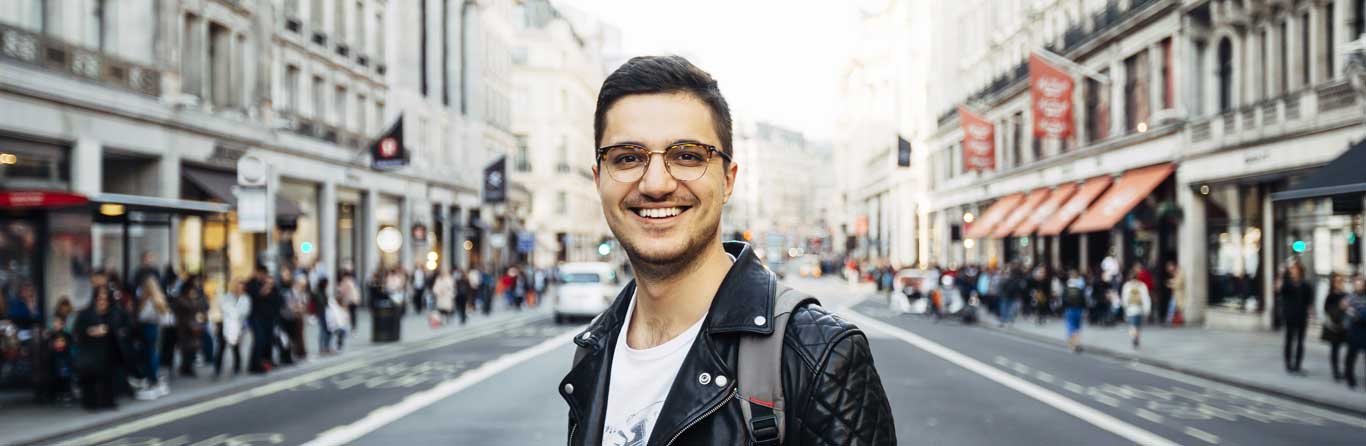 A photograph of a happy male student exploring a country
