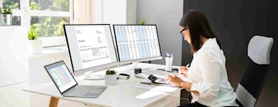 A female tax accountant working on online taxes and invoices using computer and calculator
