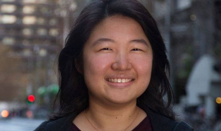 Jane is posing in the streets of Melbourne wearing a black top.