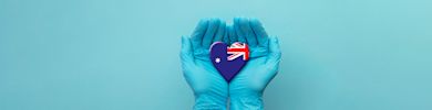 Nurse's hands wearing surgical gloves holding Australia flag heart