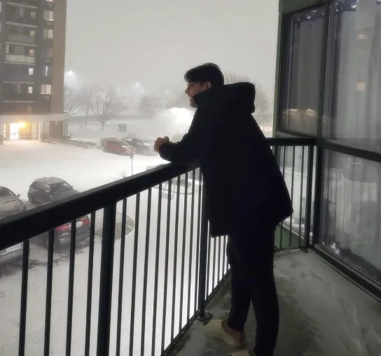 Raiyan standing on a balcony in winter