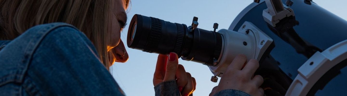 An astronomy student with a telescope