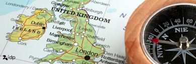 A close-up of a map showing the United Kingdom and part of Ireland, with major cities labeled. A compass is partially visible on the right, and an idp logo appears in the lower-left corner.