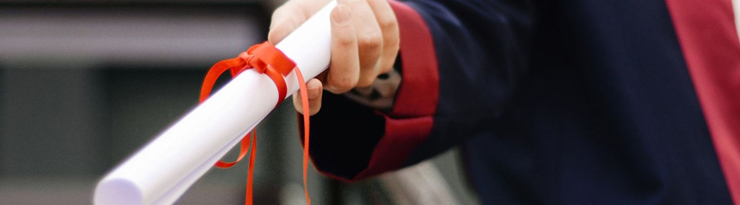 A photograph capturing a PhD student's graduation moment with their robe and certificate