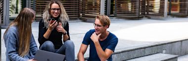 A group of international students sitting on a stairs and chatting.