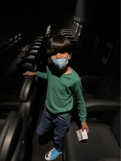 Rohan Rego's son at the theatre with a face mask.