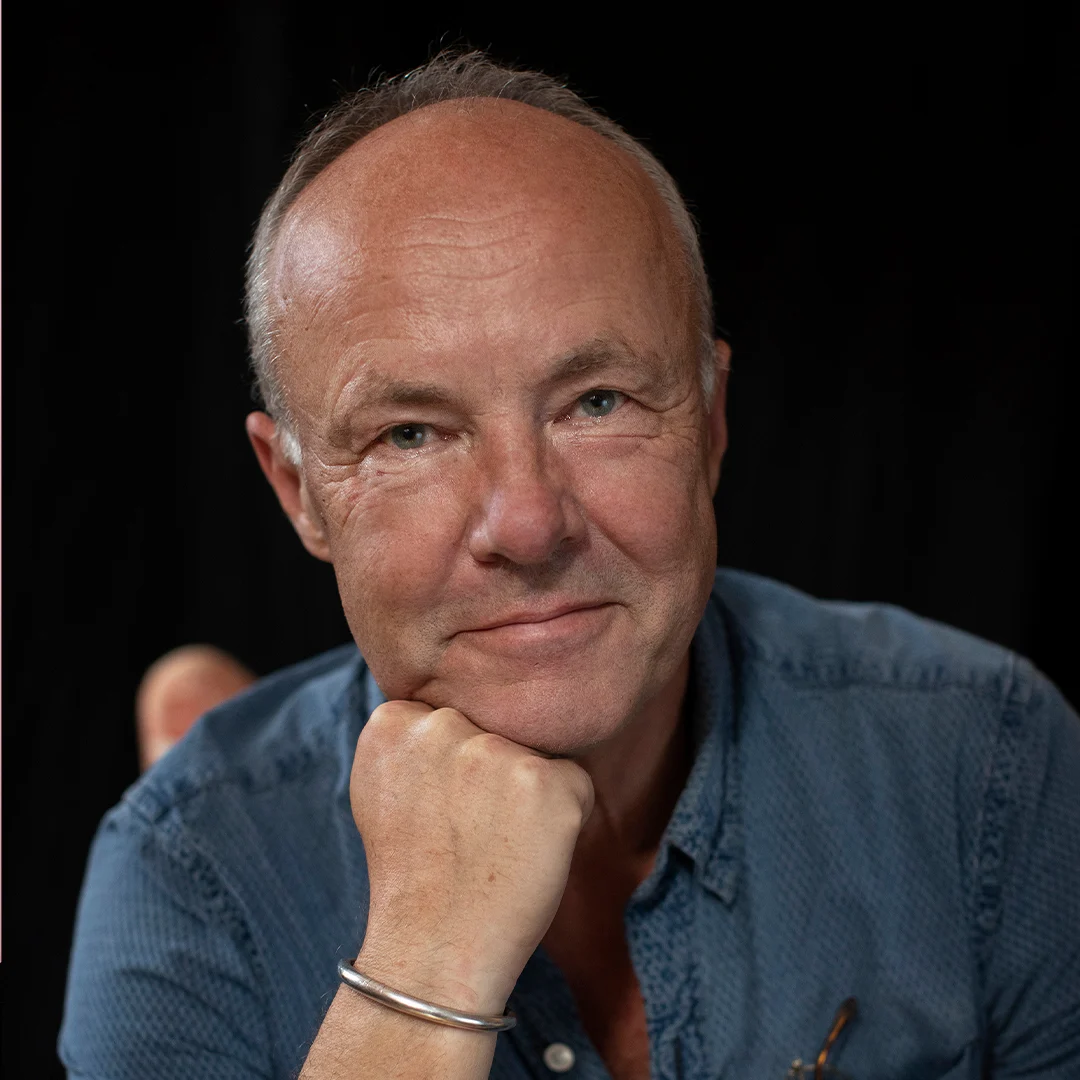 Författarporträtt av Fredrik Sjöberg, sittande med en hand under hakan.