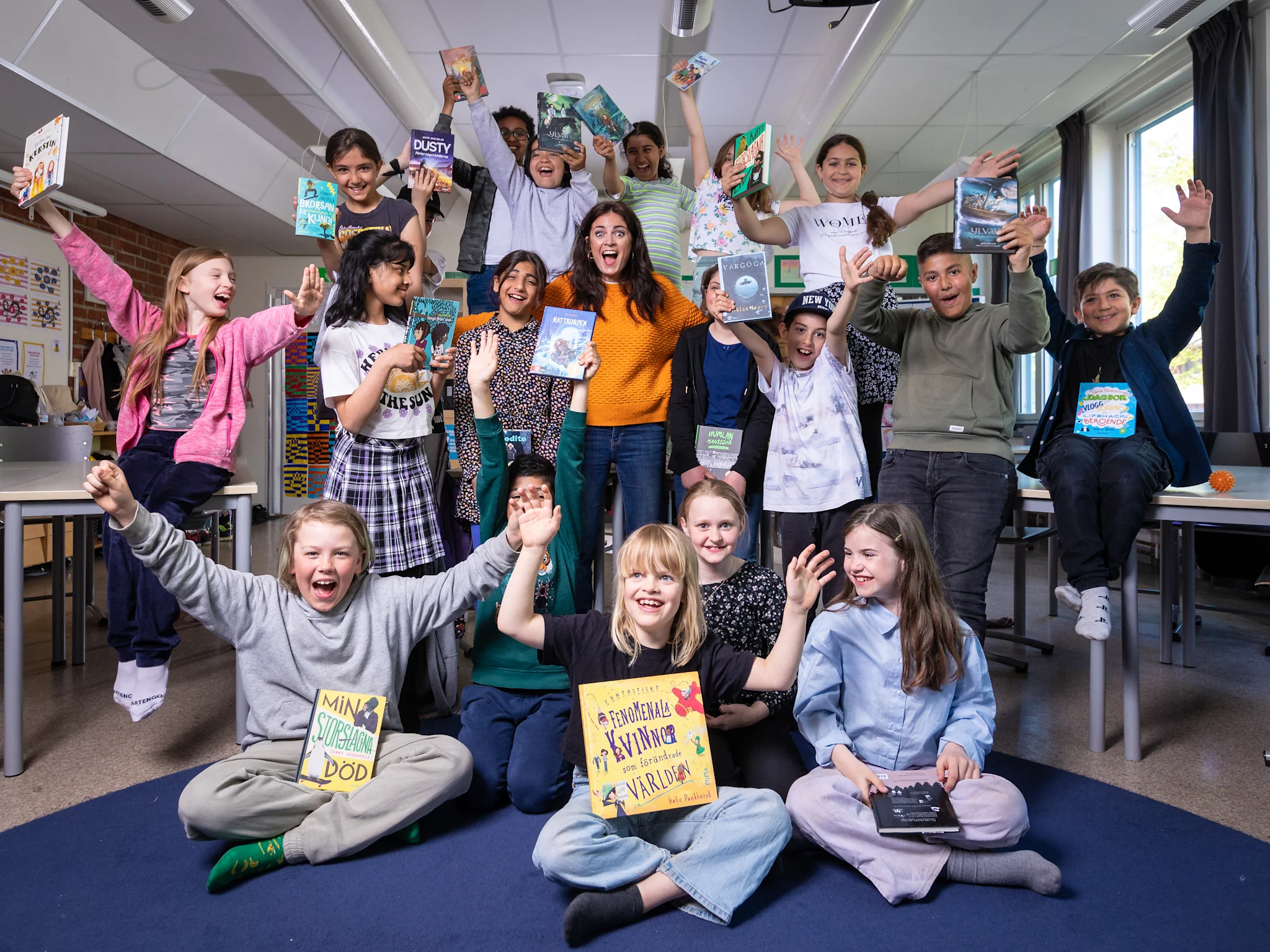 Grupp av elever på Sätraskolan som håller upp böcker under en läsutmaning.