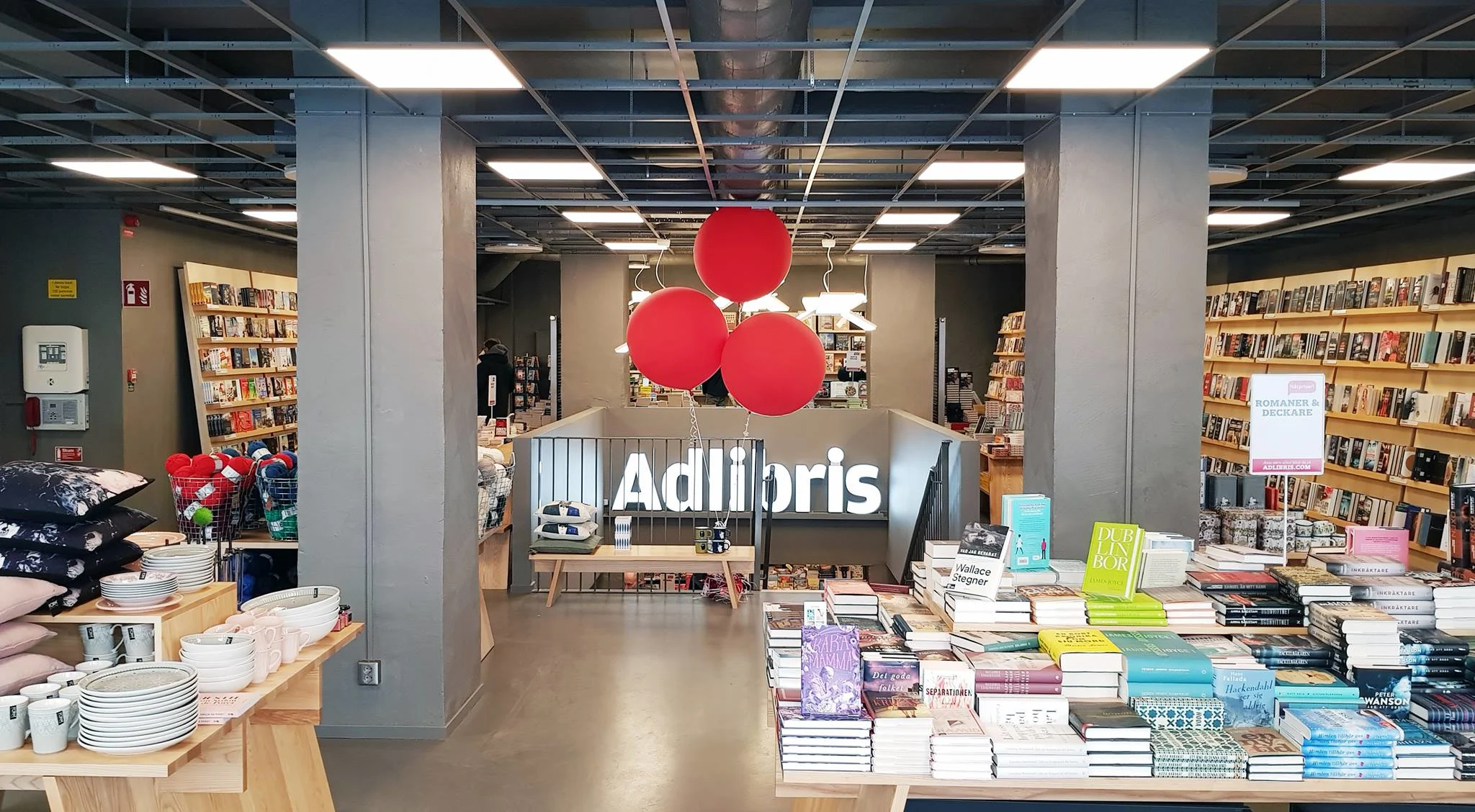 Inredning av Adlibris bokhandel med böcker och färgglada ballonger.