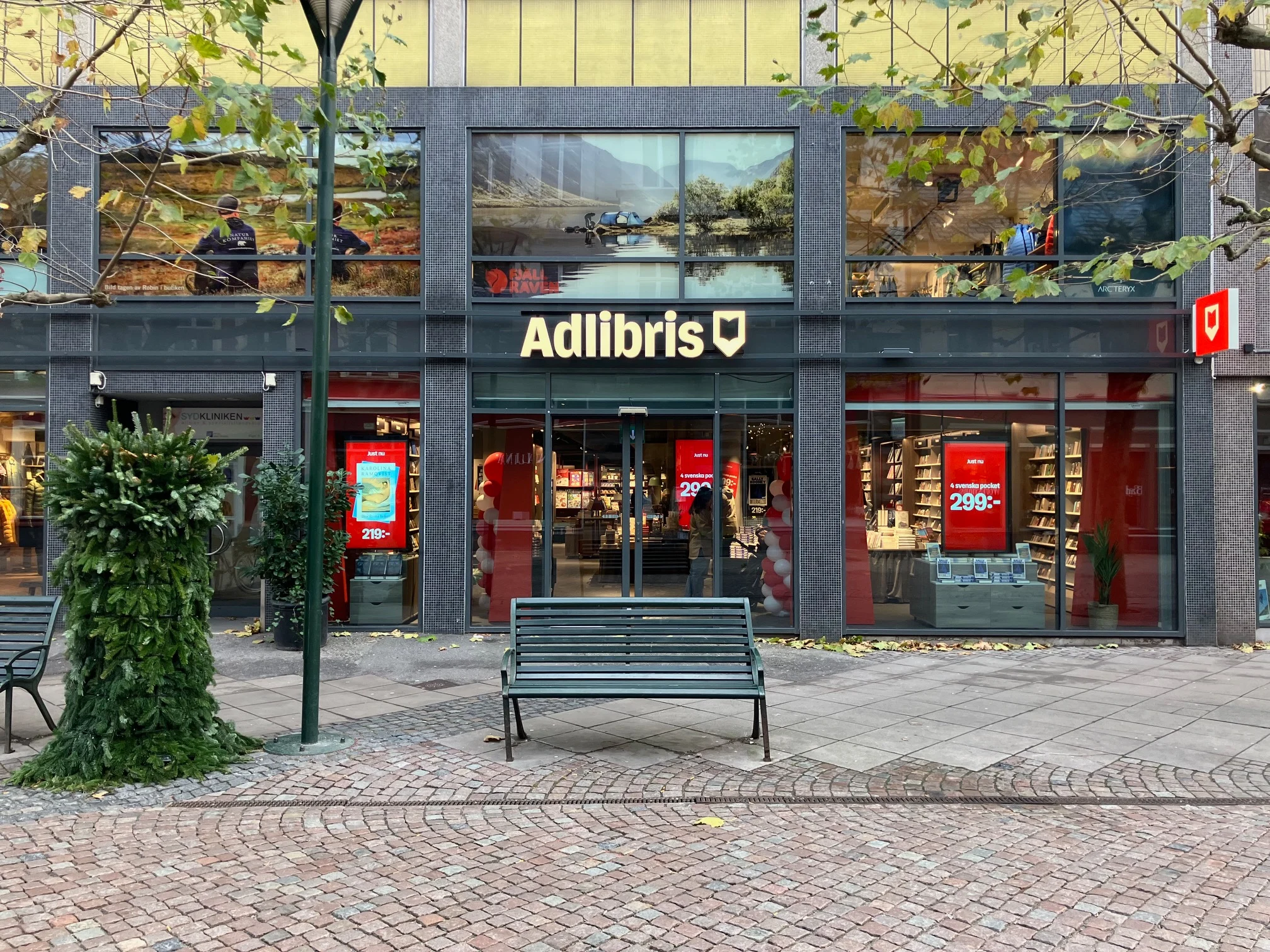Exteriör av Adlibris butik i Malmö med skyltfönster och affischer.