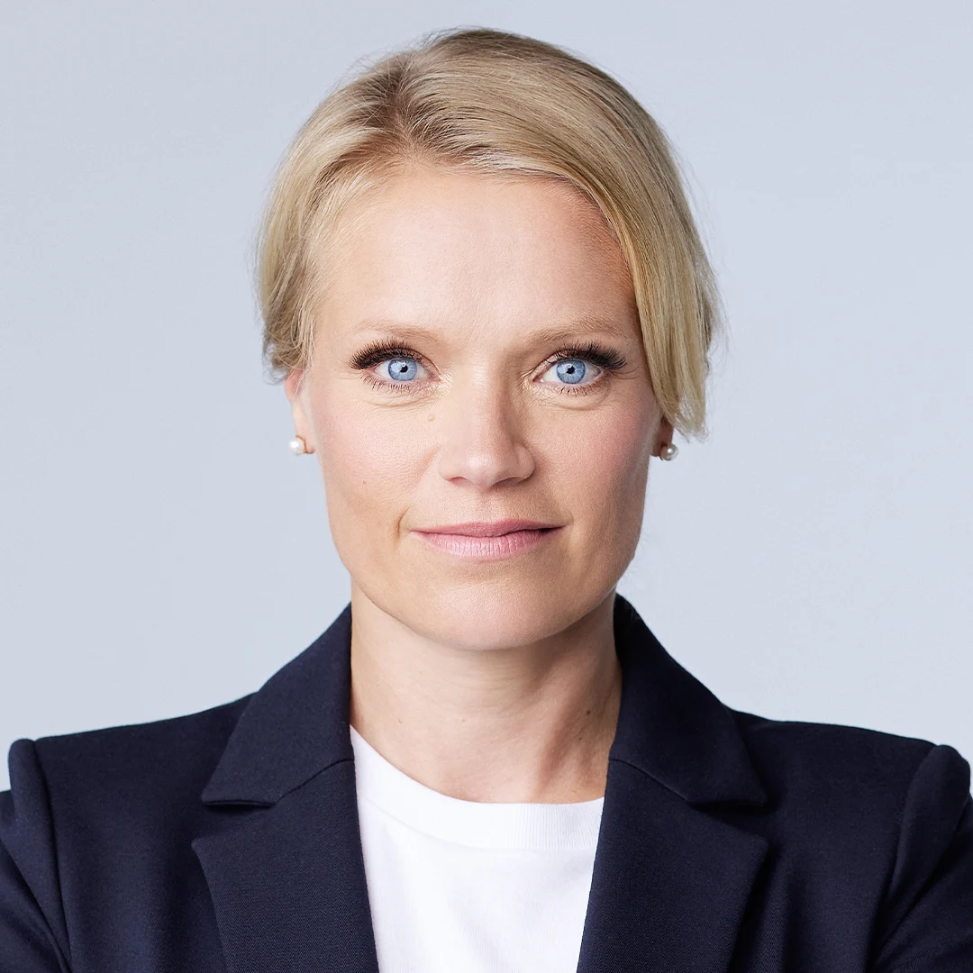 Kirjailijakuva Maaret Kalliosta, pukeutuneena mustaan pukuun ja valkoiseen puseroon.