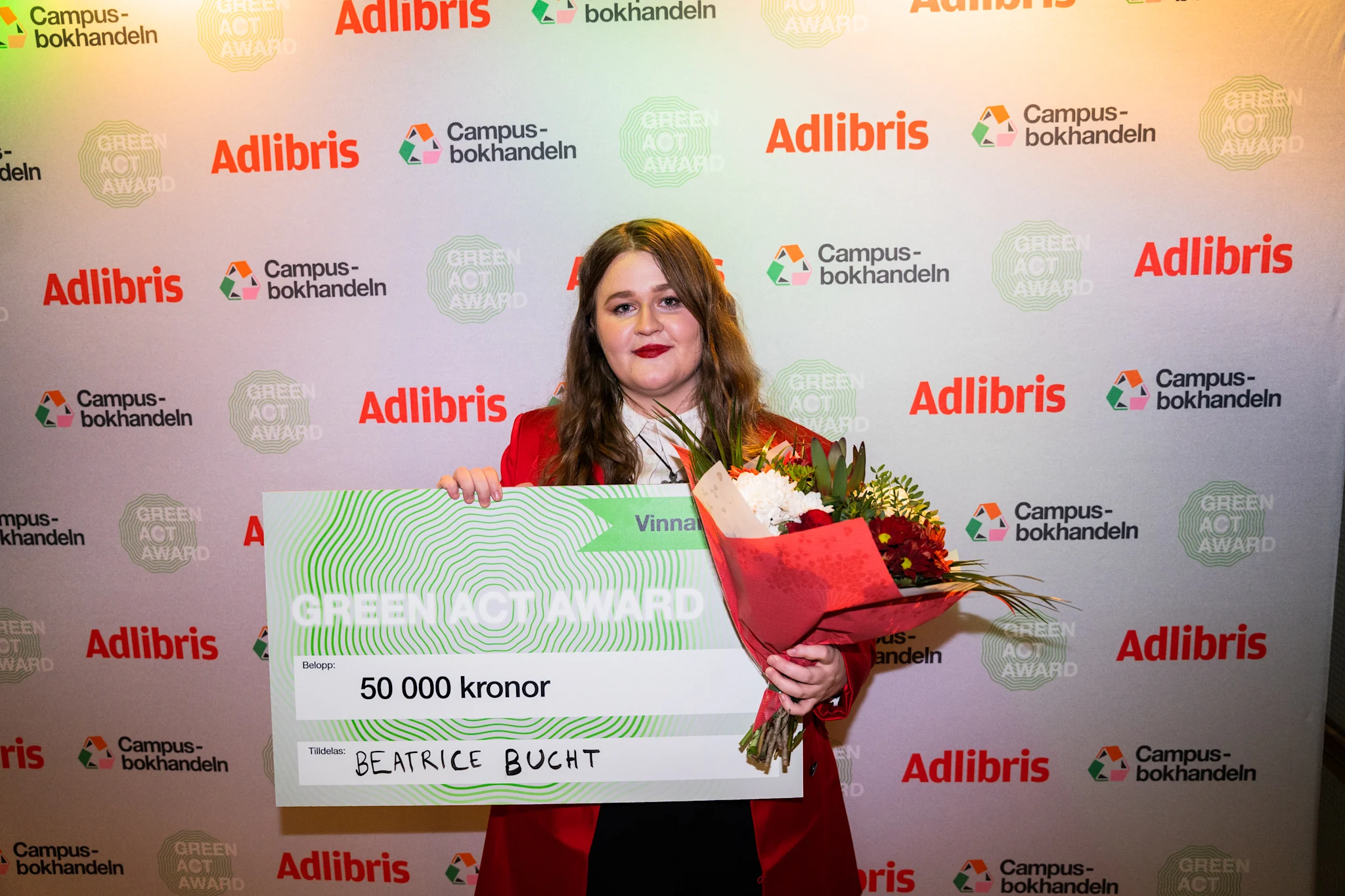 Person som håller ett diplom och blommor vid Green Act Award 2023.