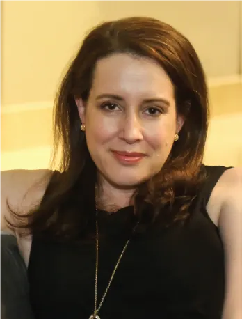 Författarporträtt av Julia Quinn, klädd i svart, med en avslappnad pose.