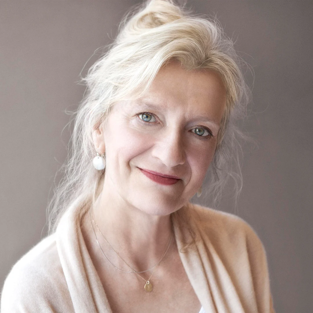 Kirjailija Elizabeth Stroutin muotokuva vaaleilla hiuksilla ja koruilla.