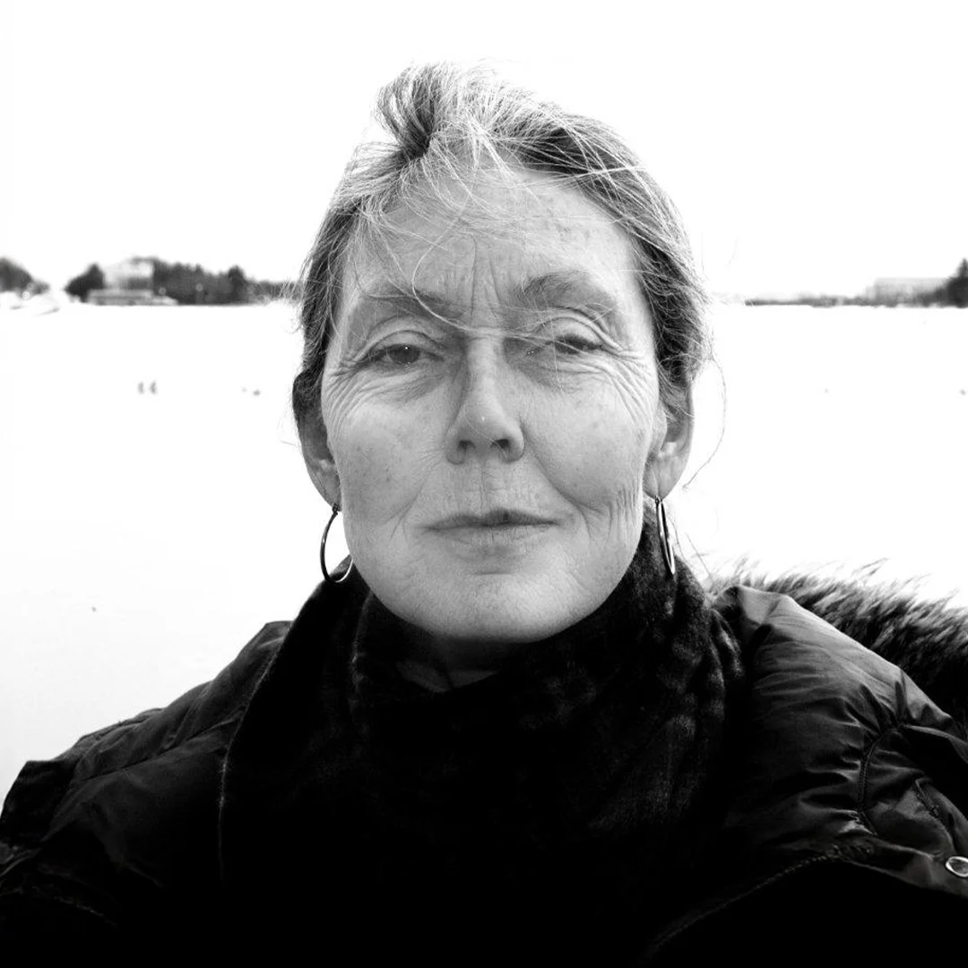 Forfatterportrett av Anne Carson i svart-hvitt, med fokus på hennes klær og omgivelser.