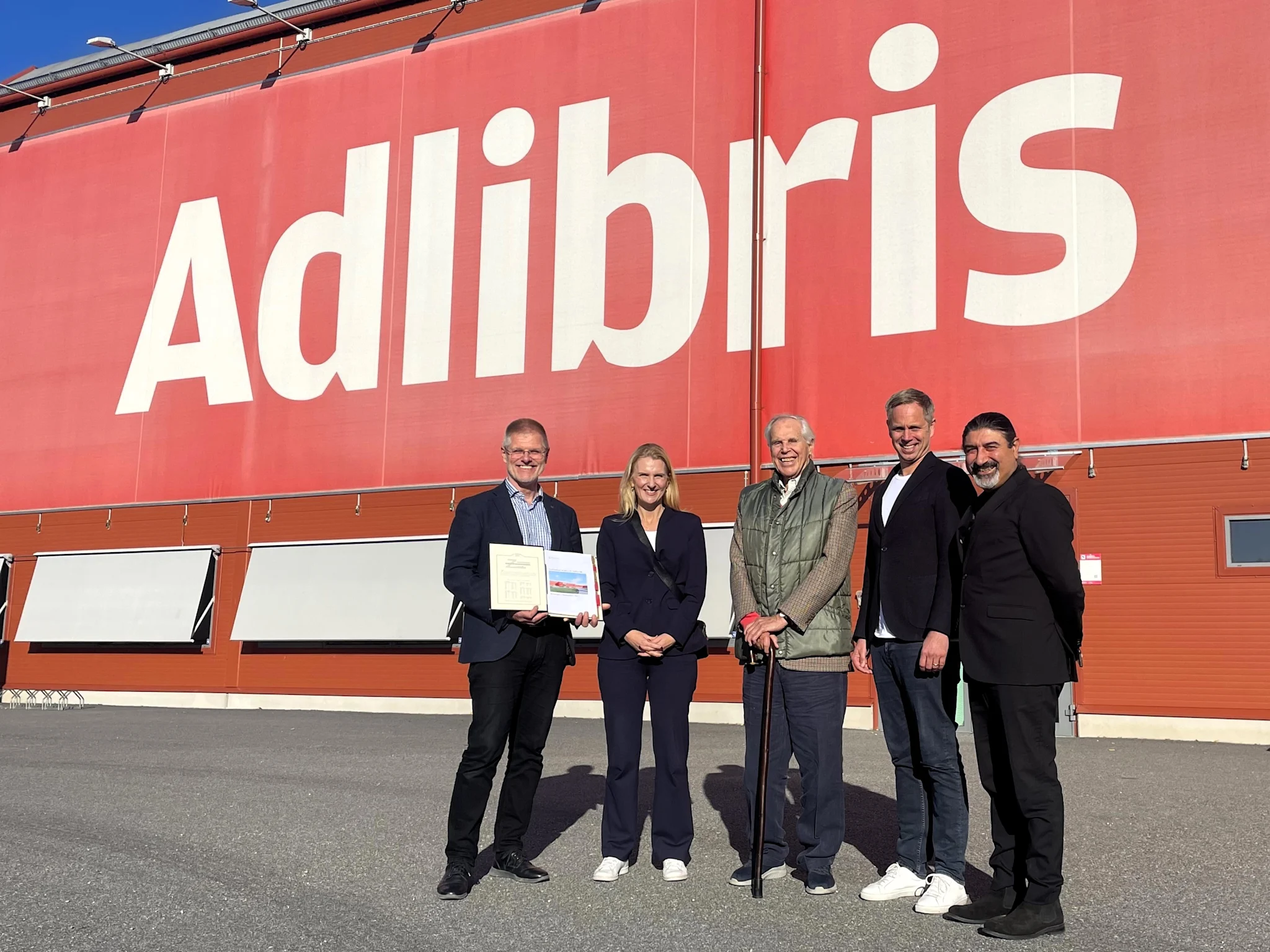 Grupp av personer framför Adlibris logistikanläggning i Morgongåva.