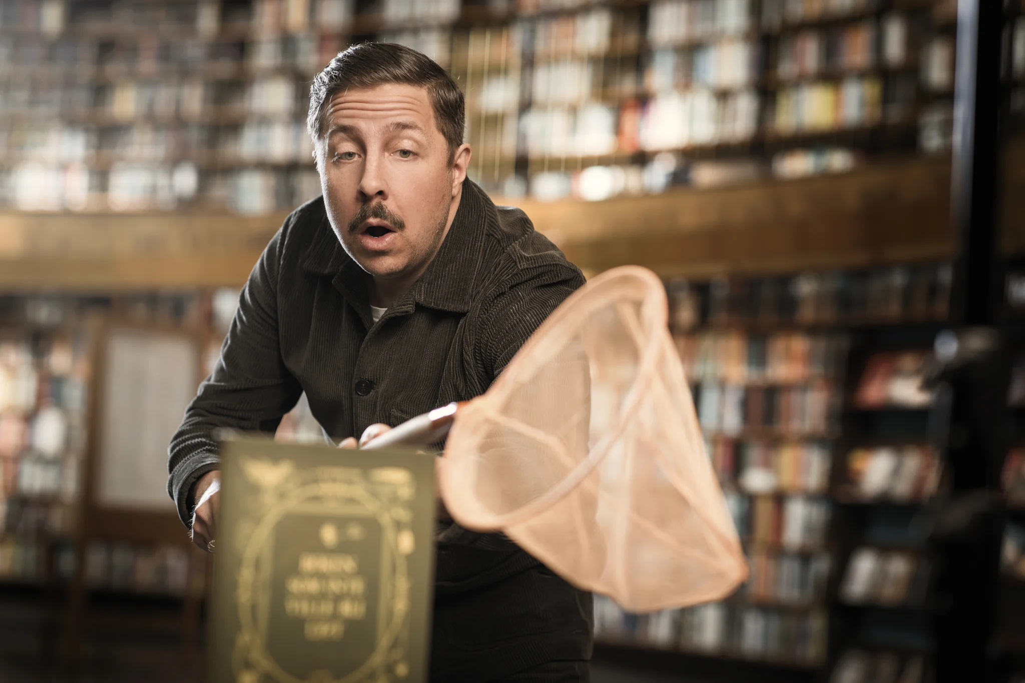 En person med en håv och en bok i en bokhandel.