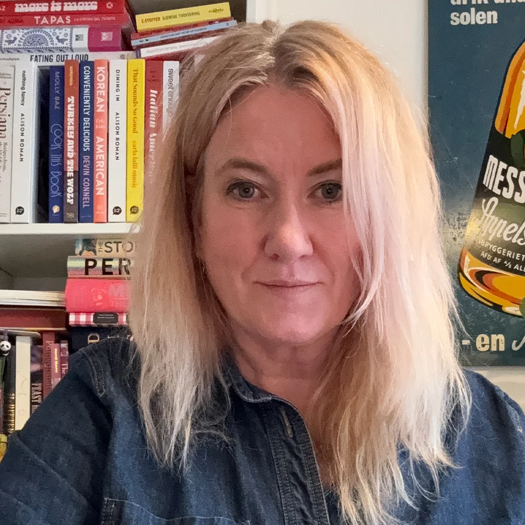 Portrett av forfatter Helle Øder Valebrokk med bøker i bakgrunnen.