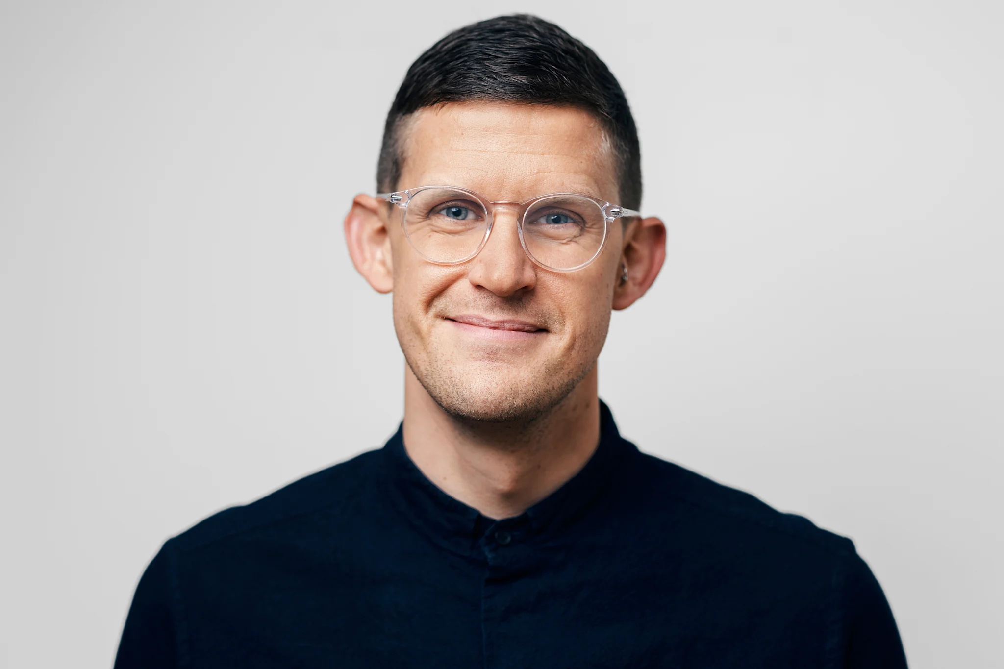 Porträtt av Kalle Norwald i en mörk skjorta mot en neutral bakgrund.