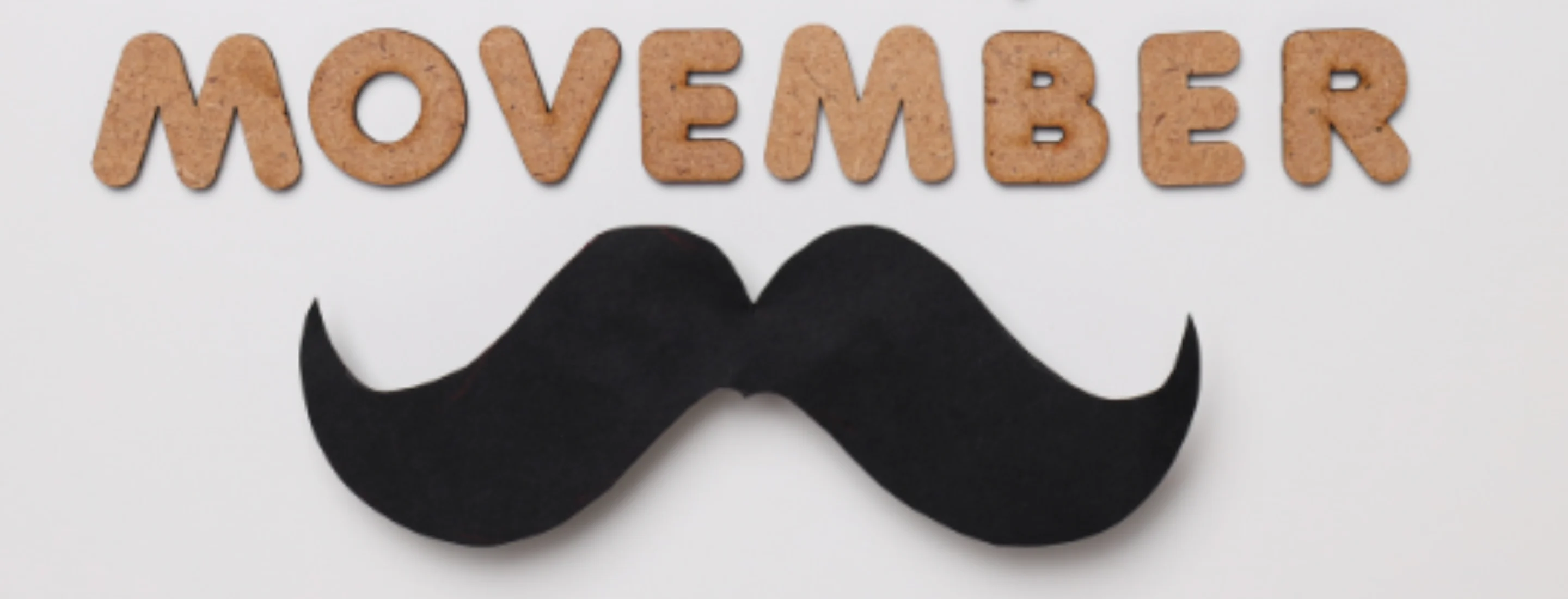 Movember sign with wooden comb and cut out moustache